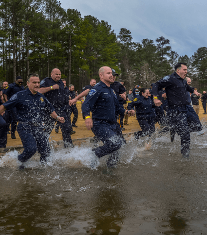 Police officers jumping in cold water