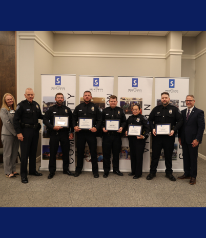 Photo shows five Pelham Police officers with their award, plus the police chief and Chamber leaders.